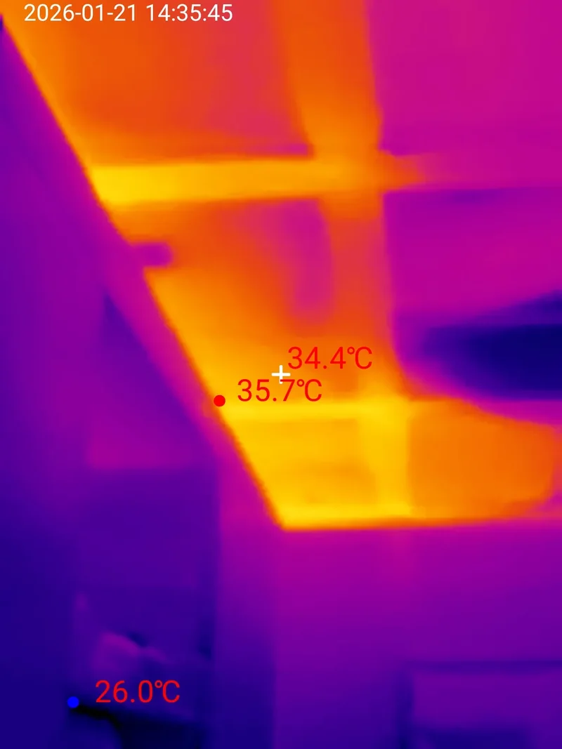 Thermal scan of a ceiling where insulated panels stay cool and dark while bays with missing insulation batts glow at 35.7 degrees Celsius