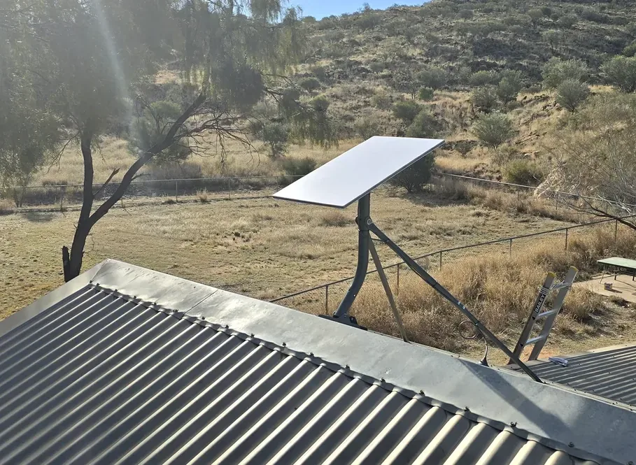Starlink installation on a rural rooftop against the hills around Alice Springs